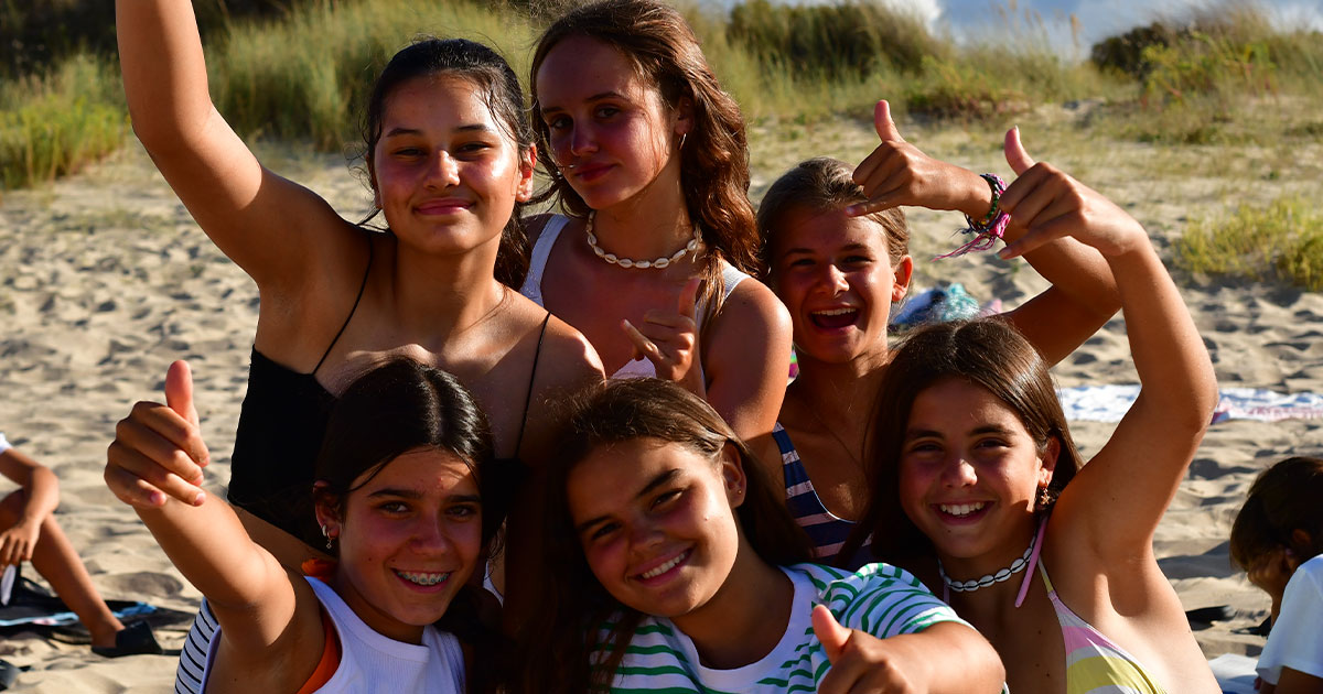 Jóvenes, niños y adolescentes disfrutando de uno de los mejores campamentos de surf de España